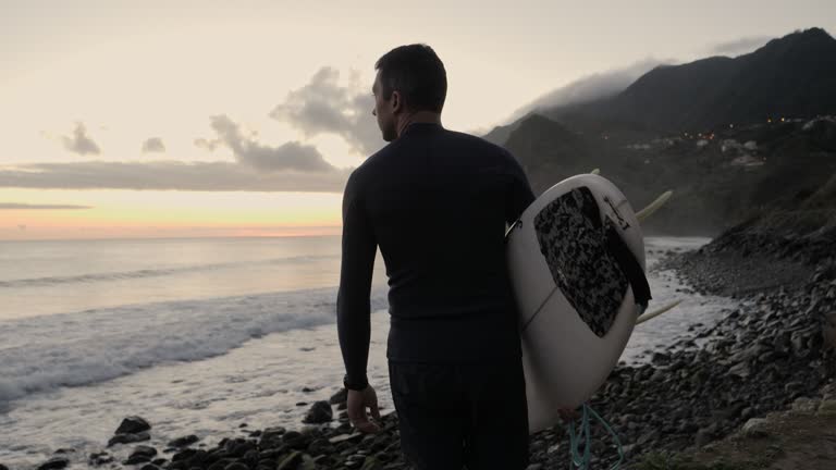 Walking with surfboard on the beach.