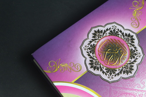 a purple Koran on a black background