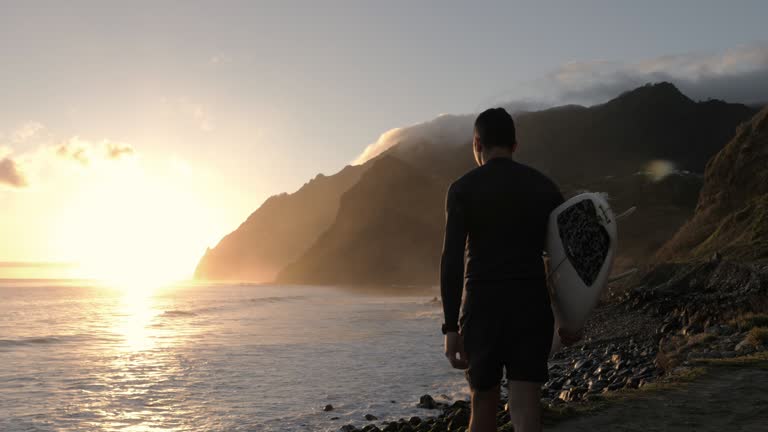 Walking with surfboard on the beach.