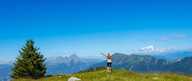 Hiker woman on the peak looking at panoramic mountain view