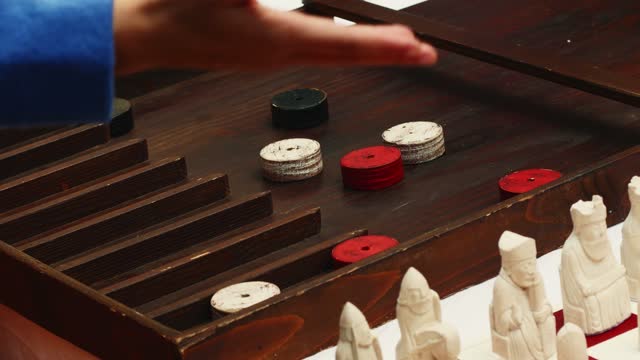 people play medieval wooden board game sjoelen board or shuffleboard