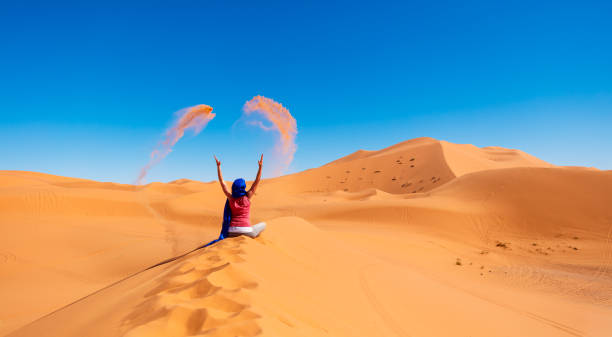 Woman in the desert threw sand- Morocco Woman in the desert threw sand- Morocco moroccan woman stock pictures, royalty-free photos & images