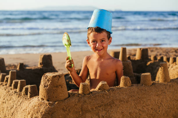 Little boy playing in the sand ,making a sand castle