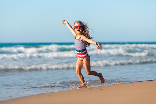 happy little girl have fun on beach, child exercise, healthy lifestye and summer vacation