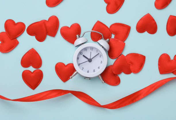 istock Alarm clock with hearts on a blue background. Valentine's Day. Top view 1479982836