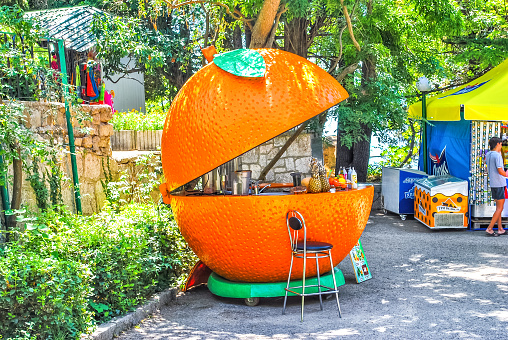 Khmelnytskyi, Ukraine - 21 July 2012: Funny kiosk in form of an orange fruit at summer city street