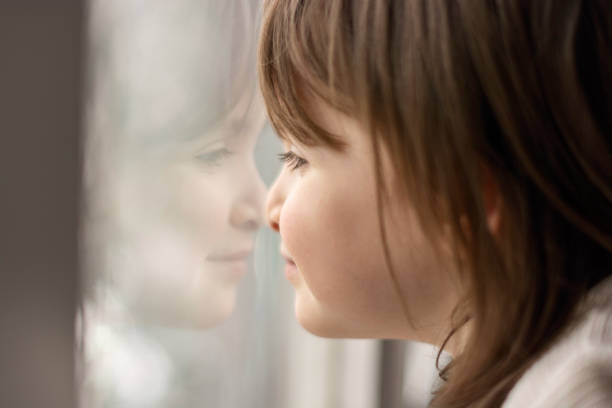 istock Cute little girl standing next to window 1479986223