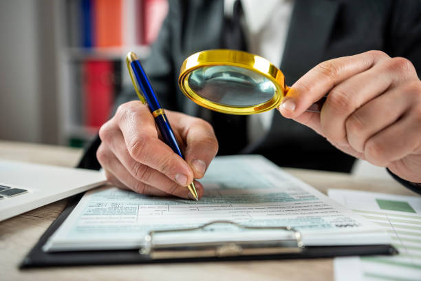 istock Male hand using magnifying glass and work with 1040 tax form 1479992077