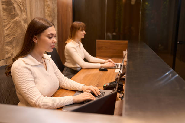 istock Concentrated women employees using notebook at reception 1479997399