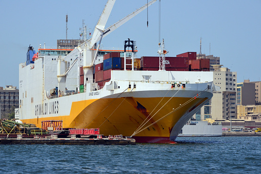 Dakar, Senegal: Grimalid Lines Grande Angola Ro-Ro / Container Carrier / Car Carrier (IMO 9343156, MMSI 247233800), bow view - Autonomous Port of Dakar (PAD), the third largest port in West Africa. CMA-CGM building in the background.