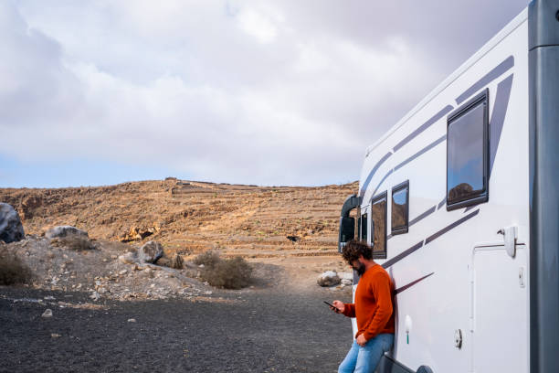 istock One traveler man using phone app outside a modern big camper van to plan road trip and next destination on technology smartphone app. Concept of scenic place and travel lifestyle. Renting vehicle 1480001925
