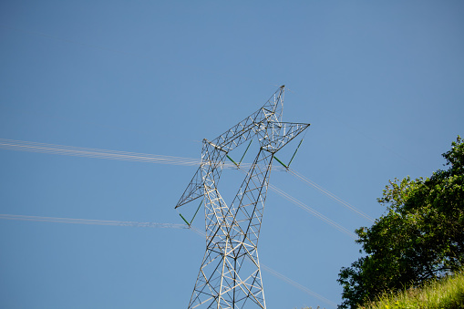 Power tower with wires on the pole passing over the mountains.