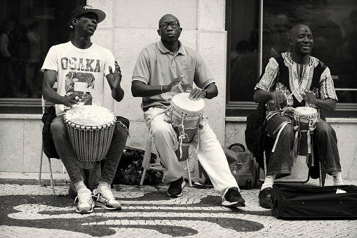 Lisbon, Portugal - October 29, 2022: A trio of african musicians play percussion at the Rua Augusta street in Lisbon downtown.
