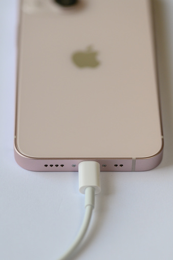 Charging an iPhone 13 mini pink with Lightning cable