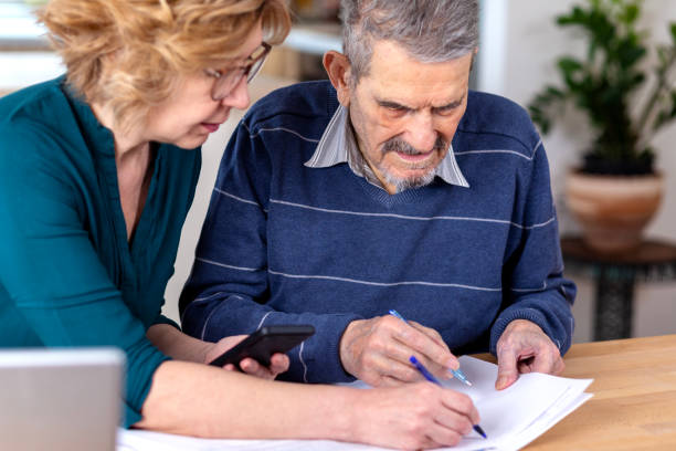 istock Woman Helping a Senior  Man With Documents And Bills 1480007729