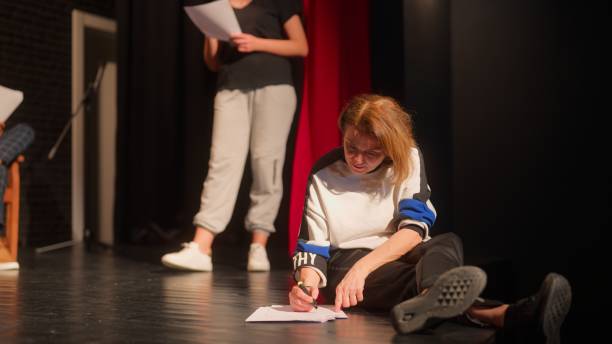 istock Group of theater stage performers checking texts and rehearsing 1480010371