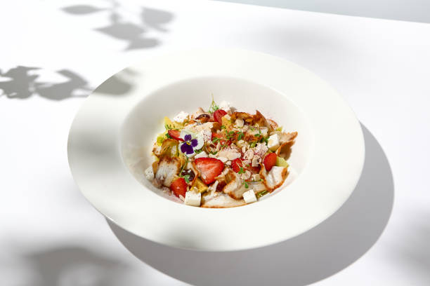 istock Elegant salad with smoked eel, strawberry and avocado on white table with harsh shadows. Eel salad with berries on white background with shadows of leaves. Romantic dining with fish appetizer. 1480011076
