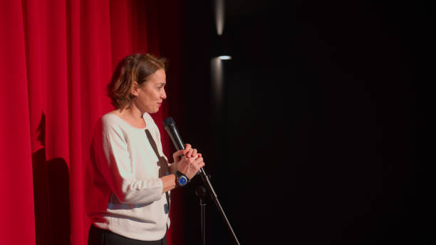 female director talking to audiences and introducing performance and play on stage - curtain stage theater theatrical performance red ストックフォトと画像