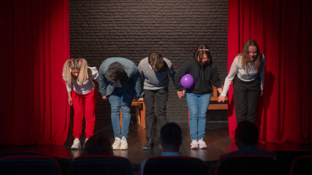 gruppo di artisti teatrali che si inchinano davanti al pubblico sul palco - improv foto e immagini stock