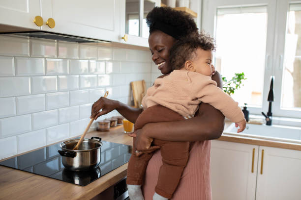 istock Multitasking mum holding her sleeping baby while she makes food in her kitchen 1480016071