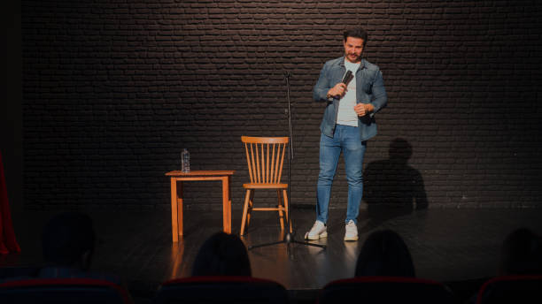 stand-up comedian maschile che parla sul palco - comico foto e immagini stock