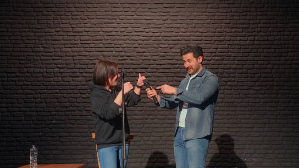 cabarettista maschile che parla sul palco e invita uno degli spettatori a salire sul palco - improv foto e immagini stock