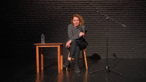 istock Female stand-up comedian talking on stage 1480017521