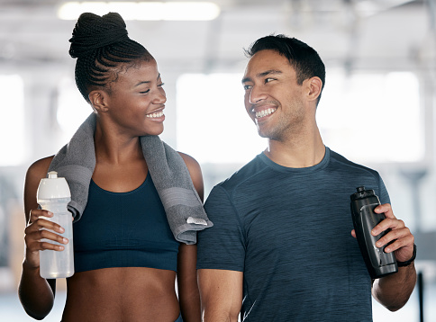 Fitness, black woman or personal trainer drinking water in training, workout or exercise on relaxing break. Coaching, partnership or sports athletes with healthy liquid for hydration or energy at gym