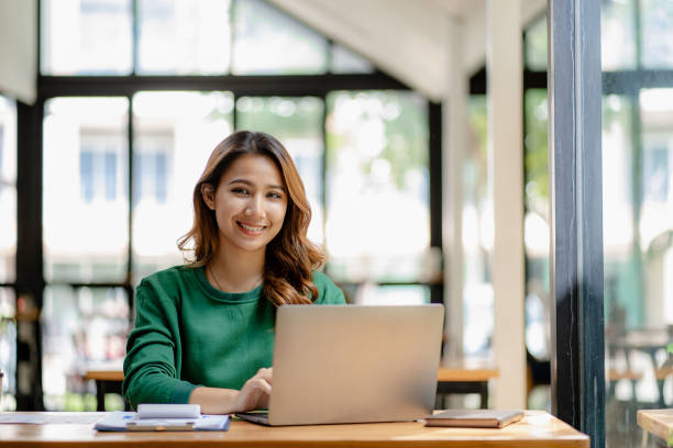 istock young woman working in a cafe using laptop and drinking coffee Asian female student using a computer for distance learning sitting on a bench in the shop casual lifestyle people and technology lifestyle 1480017703