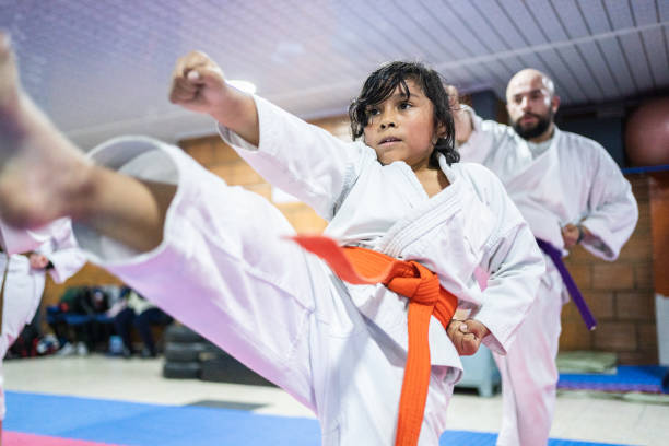 istock Child boy punching and kicking the air during a karate class 1480019893