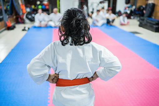 An aikido coach demonstrates warm-up exercises to a small group of young fighters