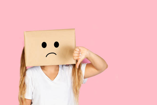 istock Woman with her head in a box, sad gesture and thumb down standing on a white background 1480022951