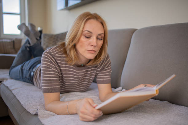 istock Woman reading book at home 1480024355