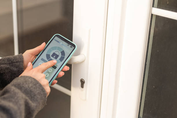istock Smiling woman setting home security system with help of mobile application. 1480026453