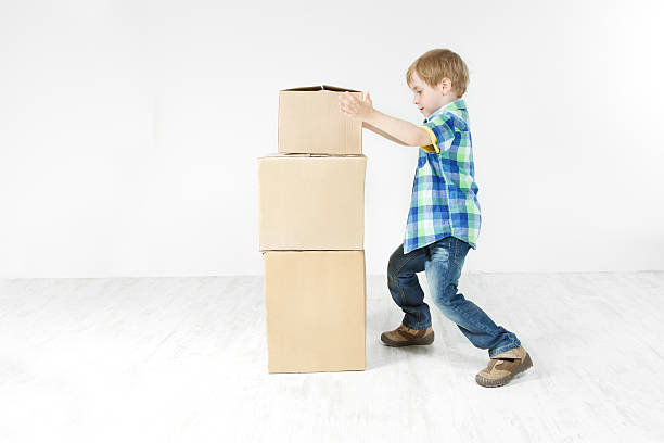 istock Boy building pyramid of carton boxes. 148002669
