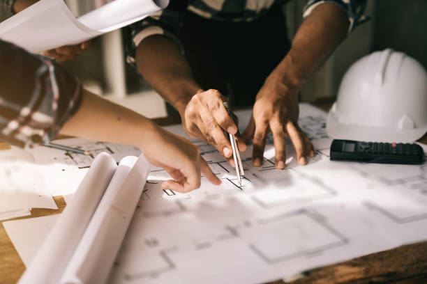 istock architect or engineer working on table use drawing tool on the paper plan for business architectural project. 1480028370