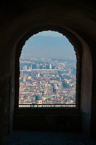 Naples, Italy - December 20, 2022: High angle view of Naples in Italy of the old, historic center of the city at sunrise seen from a small window of an old castle. Italy travel landmark view