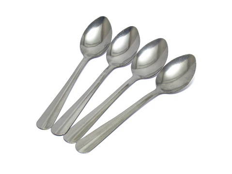 4 stainless steel spoons lined up isolated on white background with clipping path.