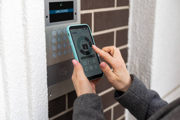 istock Young stylish woman getting access to the building by attaching smartphone to intercom. Concept of modern security technologies for access and smart home 1480033007