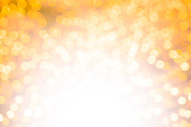 Blurred gold sparkles, defocused christmas lights. Bright bottom and middle, dark corners at the top.