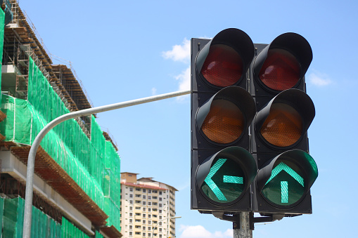 Green traffic light against blue sky