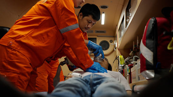 Asian emergency medical technician (EMT) or paramedic team heart pumping CPR the patient, Sudden cardiac arrest or Cardiopulmonary resuscitation concept