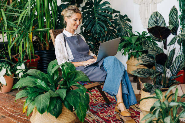 istock Female florist sits in a botanical studio and works on a laptop. 1480039219