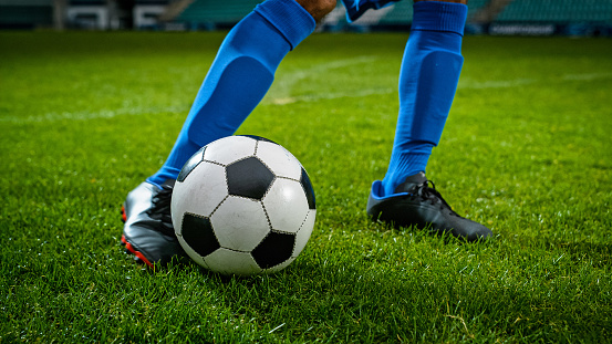 Closeup of a handballplayer holding a handball in front of the goal.