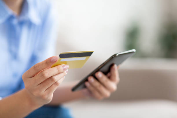 istock Unrecognizable lady holding smartphone and credit card 1480040450