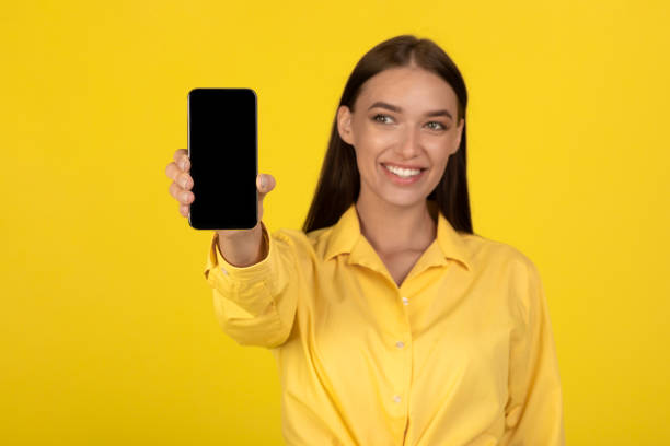 istock Positive Lady Holding Smartphone Showing Empty Screen Over Yellow Background 1480040523