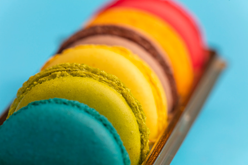 Colorful French macarons cookies on black background