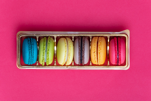 Colorful french macaroons on pink background