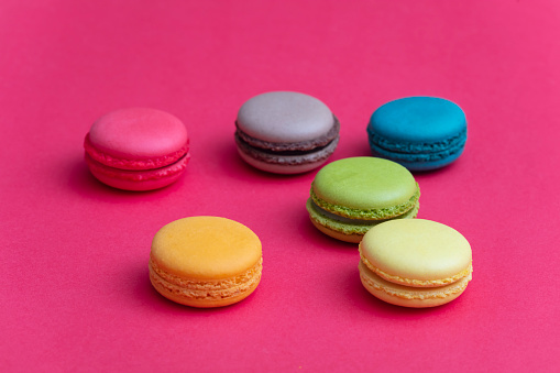 Colorful french macaroons on pink background