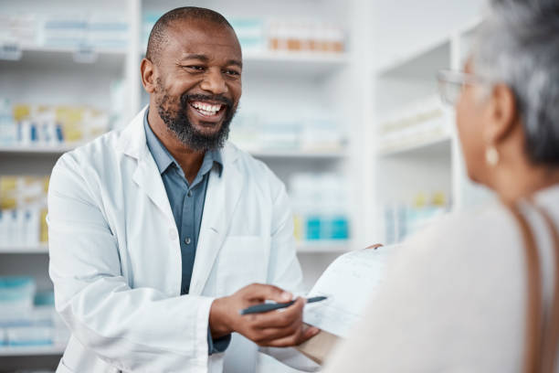 pharmacie, médecine et pharmacien en discussion avec une patiente expliquant son ordonnance. chimiste masculin des soins de santé, médical et africain parlant à une femme dans une clinique pharmaceutique ou une pharmacie. - représentation masculine photos et images de collection